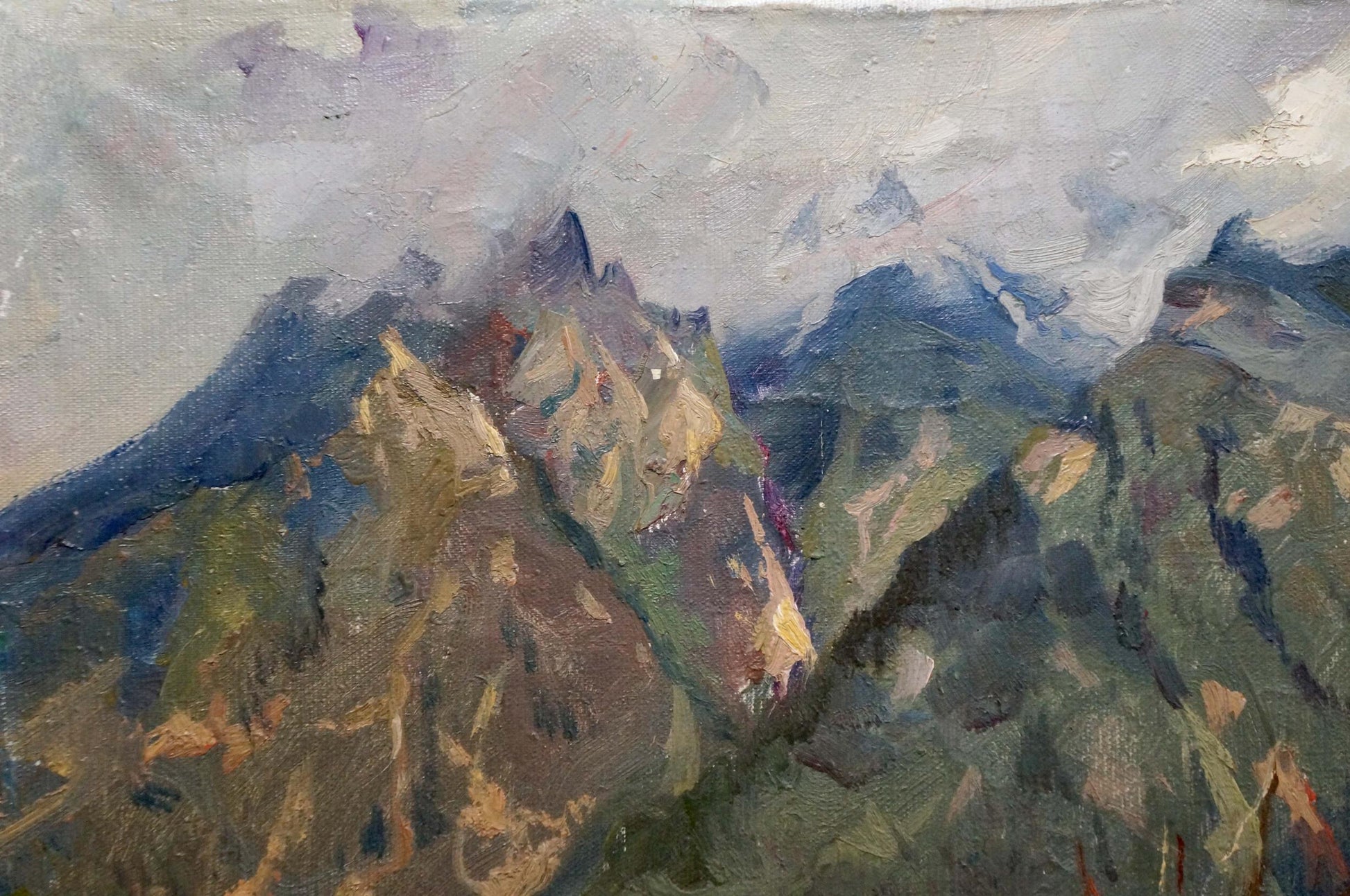 Mountain peaks surrounded by clouds were captured in an oil painting by an unknown artist